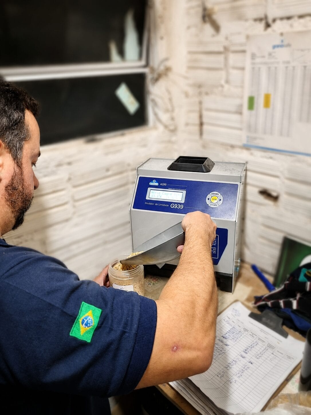 Técnico da Grano Safe abastecendo um medidor de umidade com arroz em casca durante a aferição
